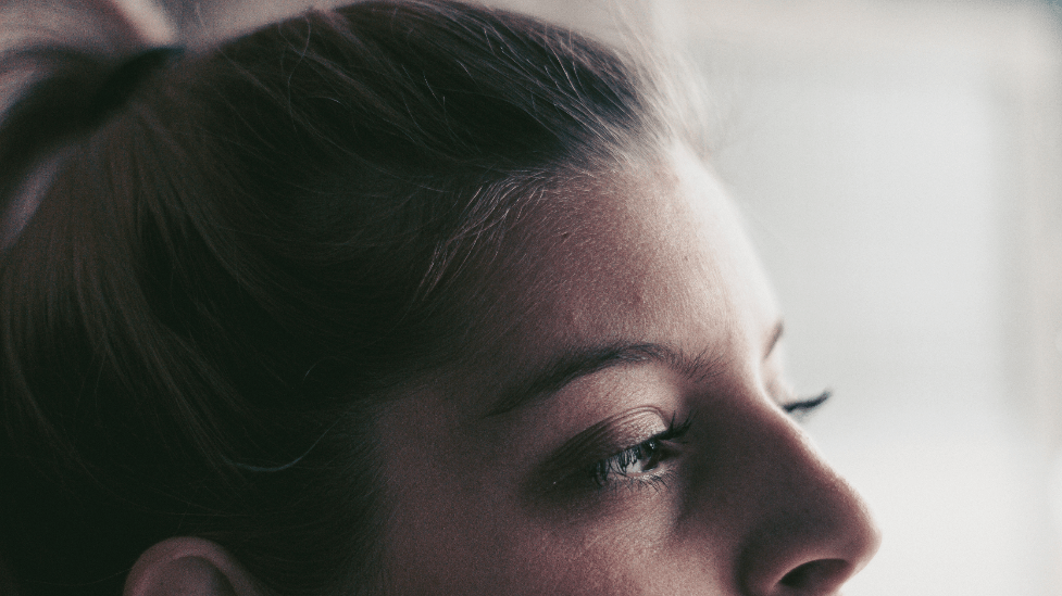 A woman looks out a window.